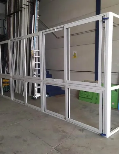 Mampara de aluminio blanco montada dentro de una nave industrial