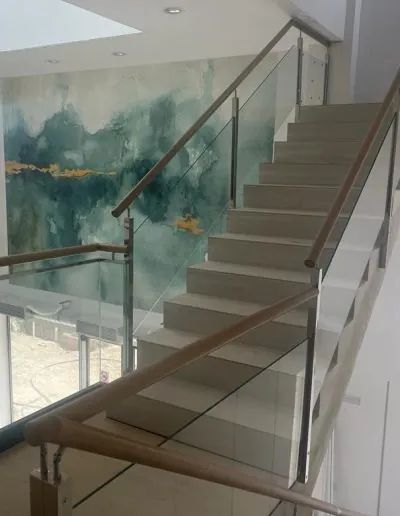 Escalera con barandilla de cristal y pasamanos de acero