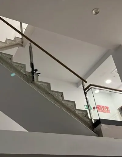 Escalera interior con barandilla de vidrio y pasamanos negro