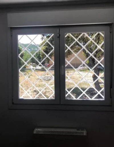 Puerta de aluminio con reja de seguridad y cristal