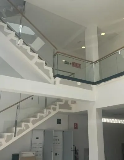 Escalera con barandilla de cristal en una vivienda de dos alturas