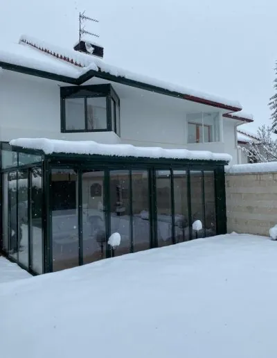 Cerramiento acristalado de un porche en un día de nieve