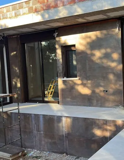 Cerramiento acristalado de perfilería marrón junto a una terraza