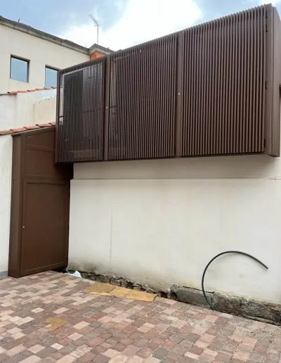 Cerramiento de lamas marrones sobre el muro de un patio trasero