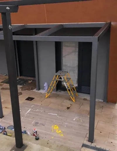 Estructura gris de una pérgola de aluminio en montaje