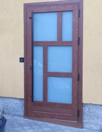 Puerta de madera con cristales de color en una fachada