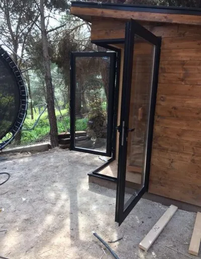 Puerta acristalada de aluminio en una caseta de madera