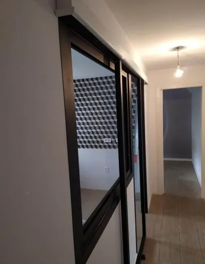Cristalera de perfilería negra en el pasillo de una vivienda