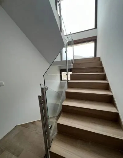 Escalera con barandilla de cristal en una vivienda de dos plantas