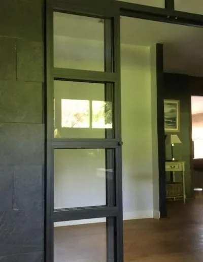 Puerta de aluminio gris con paños de cristal