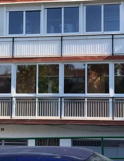 Fachada con ventanas de aluminio y barandillas metálicas