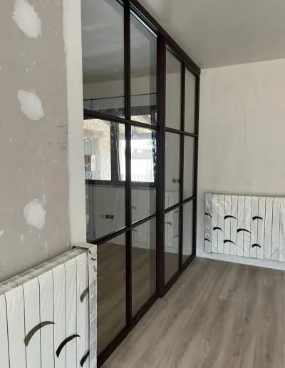 Cristalera de perfilería negra en una habitación reformada