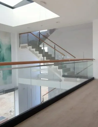 Escalera con barandilla de cristal bajo un lucernario