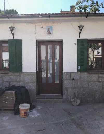 Puerta de entrada de madera con contraventanas verdes
