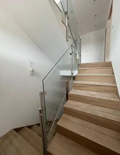 Escalera de madera con barandilla de cristal