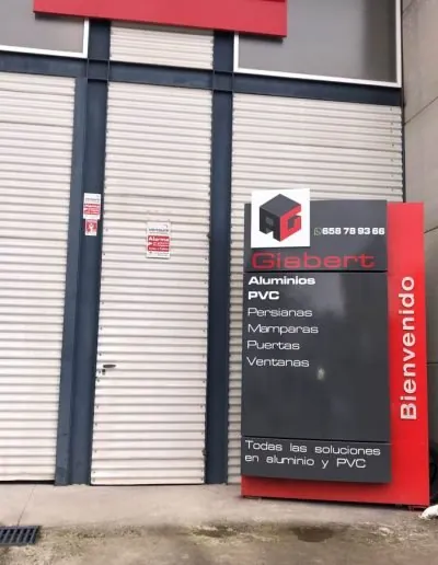 Escaparate del taller de Aluminios Gisbert con su rótulo de servicios